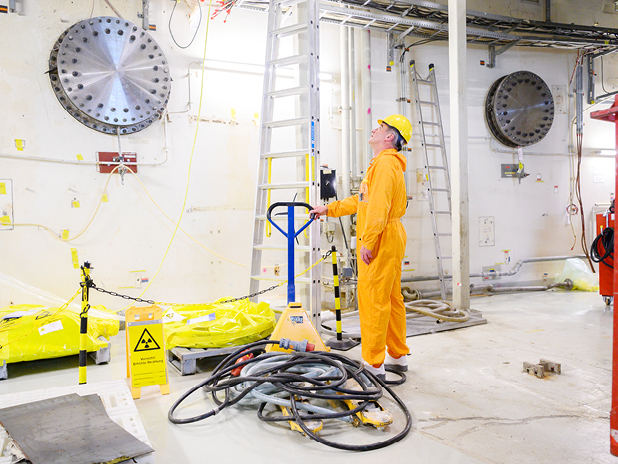 Ein Mitarbeiter steht im Kernkraftwerk Unterweser in einem Raum, in dem Demontagearbeiten stattfinden. (BildMitLangbeschreibung)