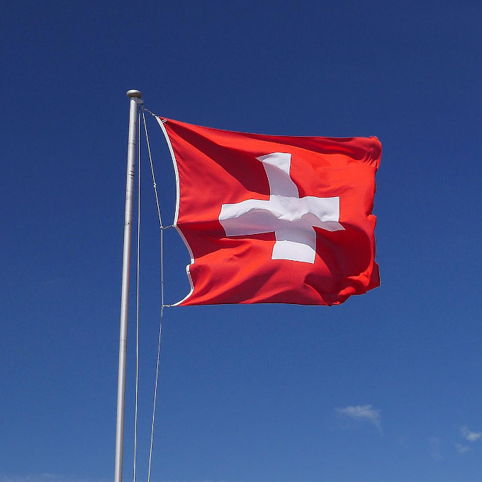 Das Bild zeigt eine im Wind wehende Flagge der Schweiz