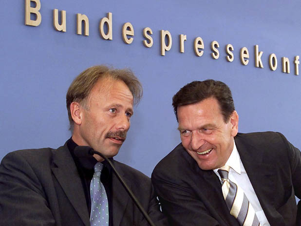 Lachend unterhalten sich Bundeskanzler Gerhard Schröder und Bundesumweltminister Jürgen Trittin am 15.6.2000 zu Beginn der Bundespressekonferenz in Berlin. (BildMitLangbeschreibung)